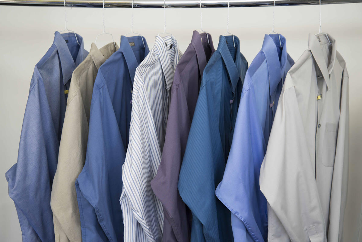 row of freshly pressed dress shirts hanging on hangers